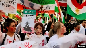 Crowd of protesters in central Tehran waving Iranian flags and banners
