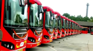 An electric bus charging at a depot alongside cyclists using a dedicated lane
