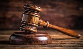 Wooden judge’s gavel resting on a sound block