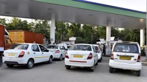Various sized cars lined up at a fuel pump station