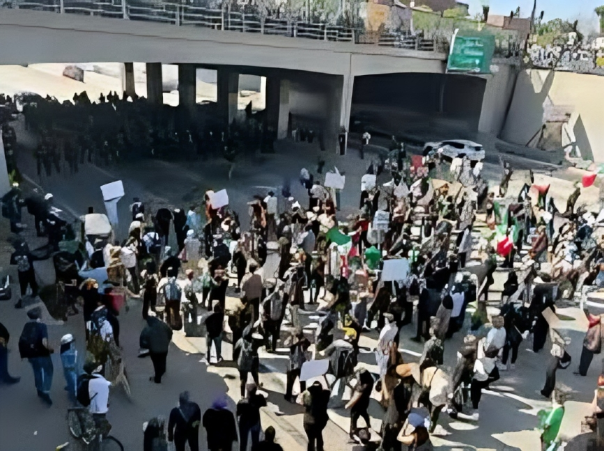 Line of detained workers sitting on ground with law enforcement standing nearby