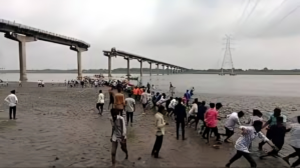 Collapsed Gujarat bridge with rescue teams at work