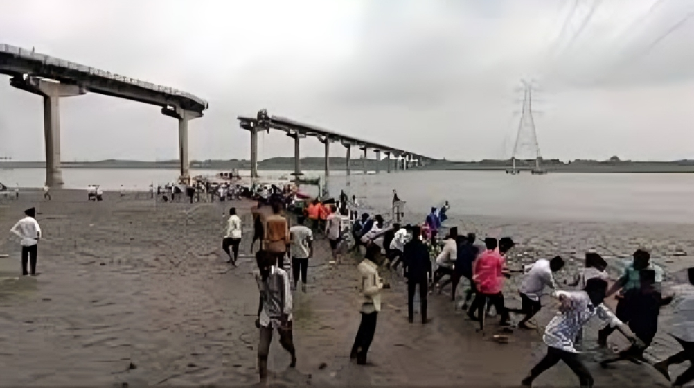 Collapsed Gujarat bridge with rescue teams at work